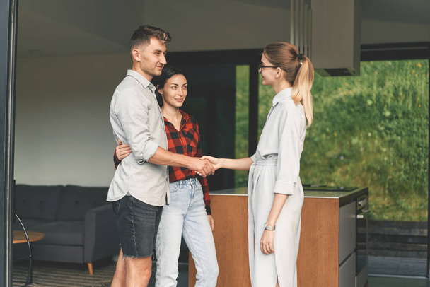 Millennial couple bought a house and shake hands with a realtor  - Foto, immagini