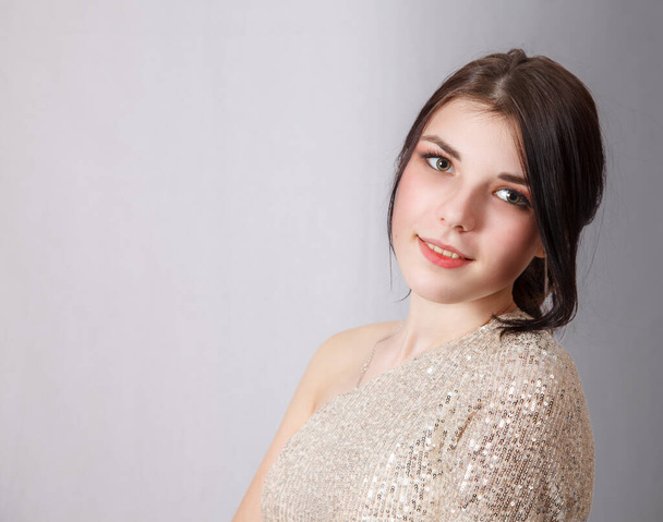 portrait of a young beautiful brunette girl in bright dress in studio on light background - Fotoğraf, Görsel