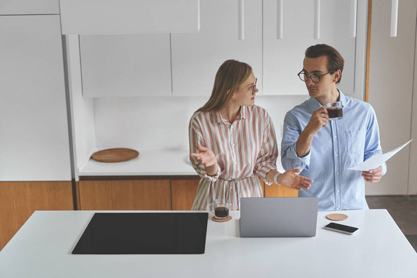 Couple familial d'homme d'affaires debout sur la cuisine moderne et travaillant à la maison - Photo, image
