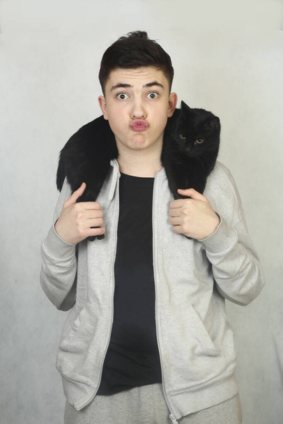 adolescente menino abraço com preto gato closeup foto isolado no branco - Foto, Imagem