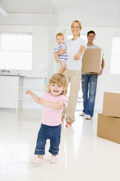 Family with box moving into new home smiling - Valokuva, kuva