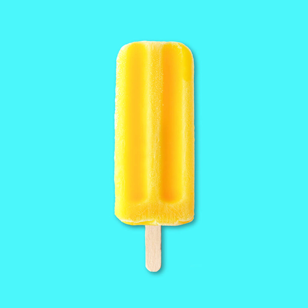 Gelber Sommer-Eispop vor leuchtend blauem Hintergrund - Foto, Bild