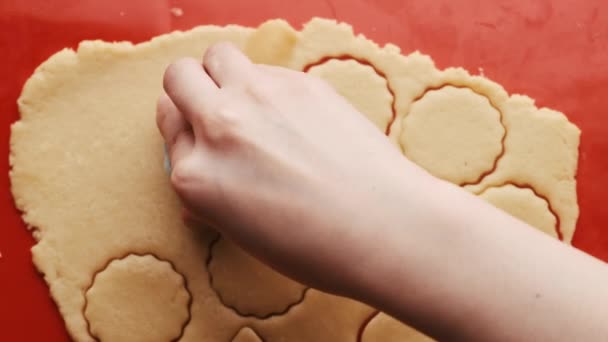 Kadının eli kırmızı silikon hasırın üzerinde yuvarlak şekilli kurabiyeler yapıyor..  - Video, Çekim