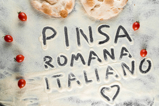 Pâte et farine avec texte pinsa romana italiano sur fond noir. Scrocchiarella cuisine gastronomique italienne. Plat traditionnel en italie - Photo, image