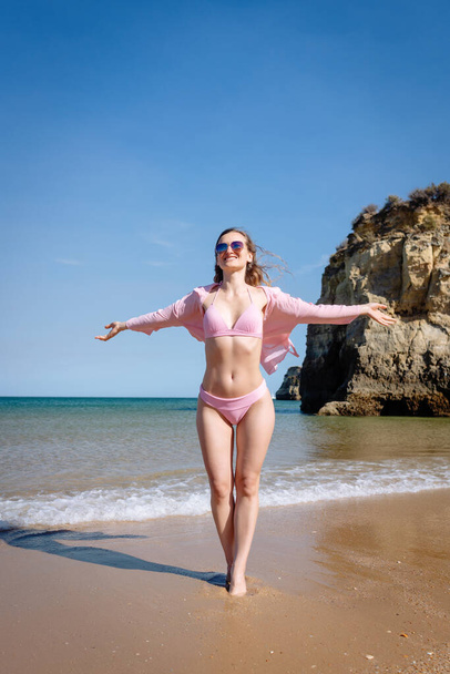 Toeristische vrouw geniet van het strand van Portugal in haar vakantie - Foto, afbeelding