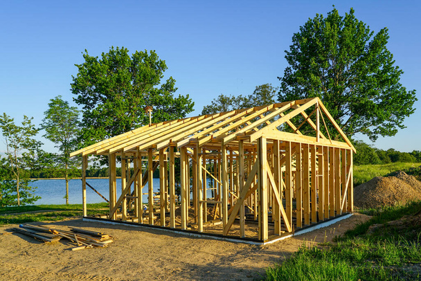 строительство простого деревянного дома отдыха на берегу озера - Фото, изображение