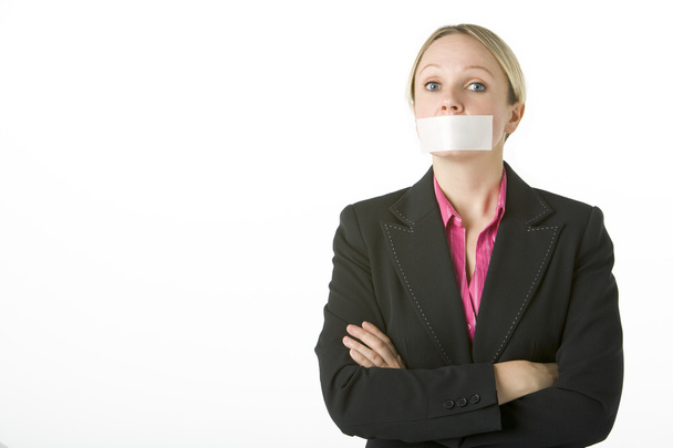 Businesswoman With Her Arms Folded And Mouth Taped Shut - 写真・画像