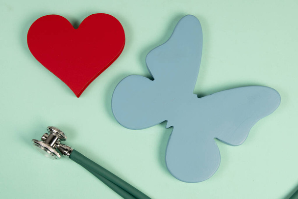 Mariposa que simboliza la tiroides y la forma de un corazón que relaciona el tratamiento de los problemas asociados con los 2 órganos - Foto, Imagen
