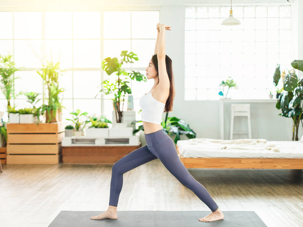 young woman, wearing casual sports clothing, exercises at home every day, stretch exercises, yoga, fitness - Photo, Image