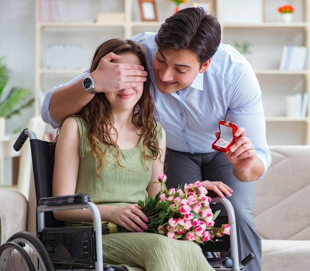 Mies tekee kosinnan vammaisen pyörätuolissa istuvan naisen kanssa - Valokuva, kuva