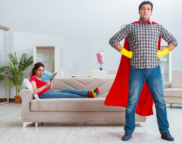 Superhéroe marido ayudando a su esposa en casa - Foto, imagen