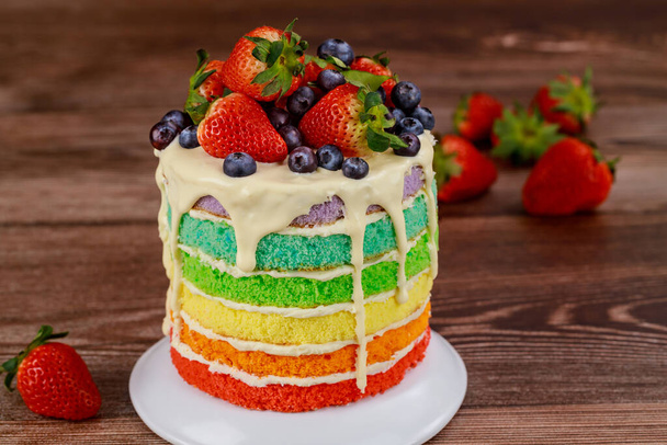 Rainbow birthday cake decorated with fresh berries. - Photo, Image