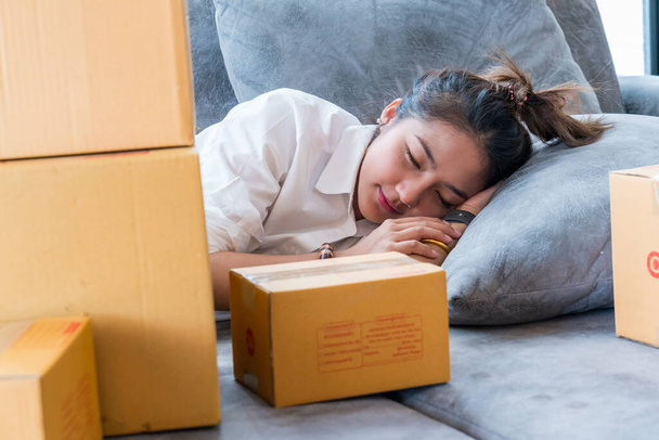 Mulheres asiáticas bonitas dormem no sofá com muitas caixas de pacotes com pequenas empresas vendem ao cliente em compras on-line. - Foto, Imagem