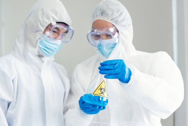 Dois asiáticos cientista equipe reservam química ciência tubo experimento biotecnologia amostra de anticorpos em laboratório Cultivate Vacina contra o vírus covid-19. Cientista consultar, analisar no laboratório de química - Foto, Imagem
