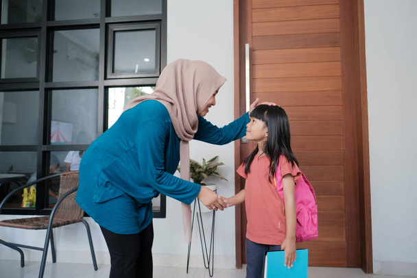 primary school female student shake and kiss her muslim mothers hand - Fotografie, Obrázek