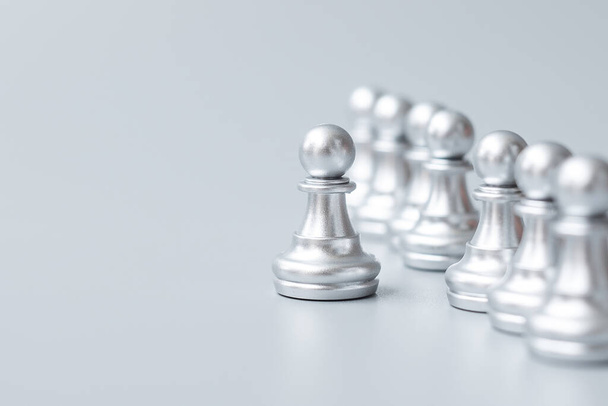 Серебряные шахматные пешки или лидер бизнесмена выделяются среди толпы людей. лидерство, бизнес, команда, командная работа и концепция управления человеческими ресурсами - Фото, изображение