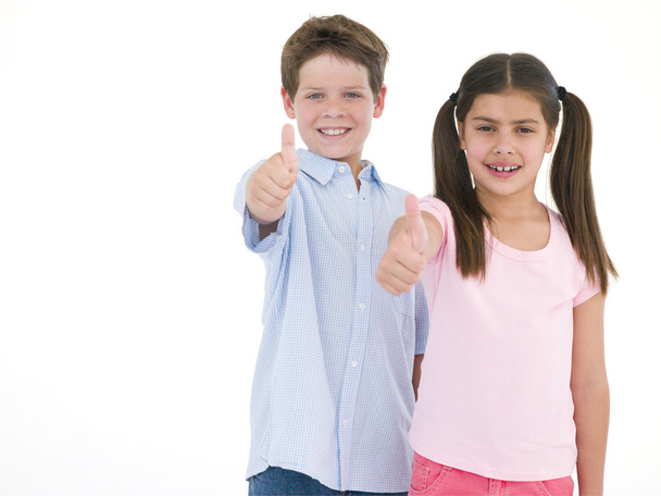 Brother and sister giving thumbs up smiling - Фото, изображение