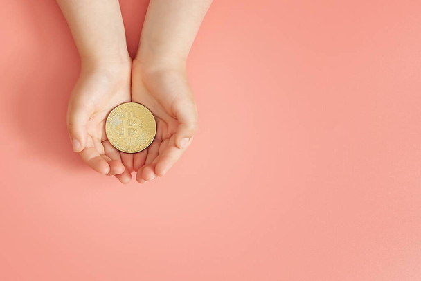 Hands holding bitcoin, world bitcoin day, investing in future children, stability during coronavirus, family investment, corporate social responsibility, investment concept - Photo, Image