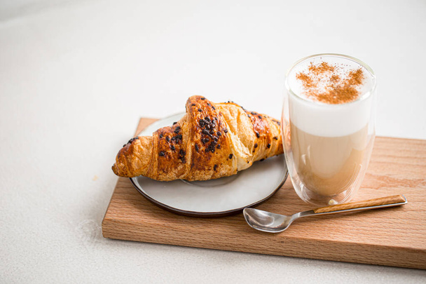 Sklenice kávy latté se skořicí a croissantem - Fotografie, Obrázek