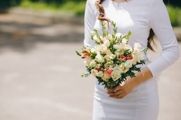 Крупним планом руки нареченої тримають красивий весільний букет
 - Фото, зображення