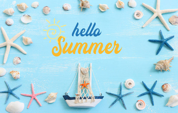 nautical concept with white decorative sail boat, seashells over blue wooden background - Foto, immagini