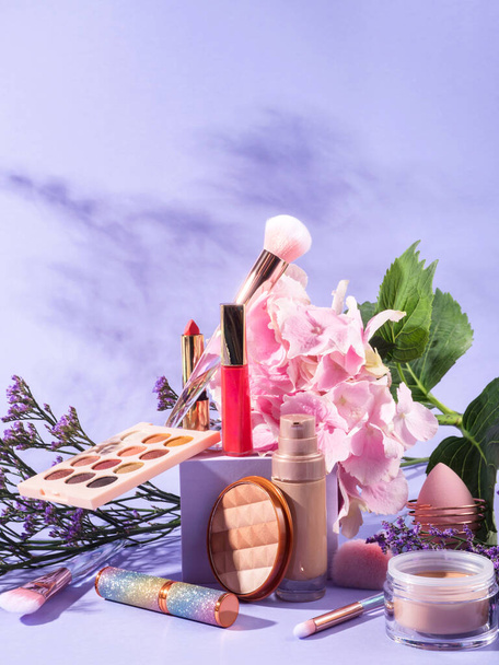 Grupo de productos de maquillaje con cepillos sobre fondo púrpura escena con podio cubo - Foto, Imagen
