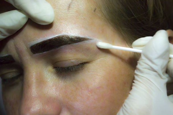 Ein Mädchen unterzieht sich im Heim einer Augenbrauenkorrektur. Eigenheimgeschäft. - Foto, Bild