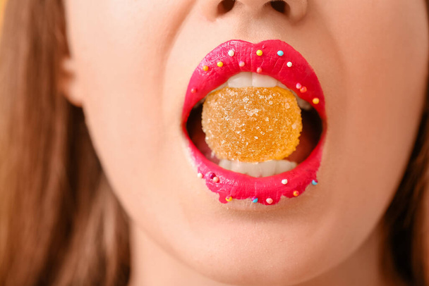 Beautiful young woman with creative makeup and sweet candy, closeup - Foto, imagen