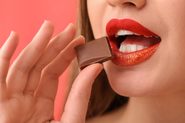 Beautiful young woman with sweet chocolate, closeup - Photo, Image