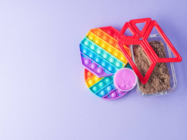 Set van kleurrijke fidget speelgoed te helpen verminderen stress en angst bij kinderen en volwassenen op paars - Foto, afbeelding