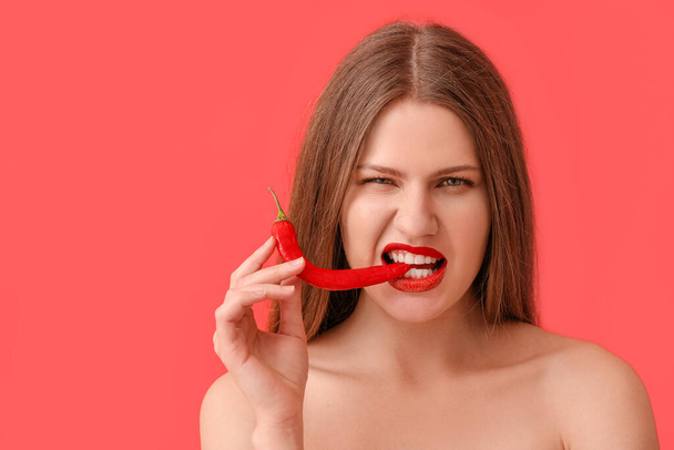 Sexy young woman with chili pepper on color background - Φωτογραφία, εικόνα