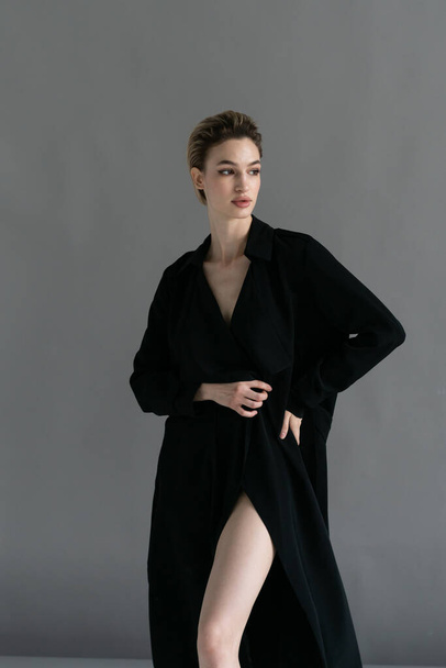 joven hermosa mujer posando en una capa negra en el estudio - Foto, imagen