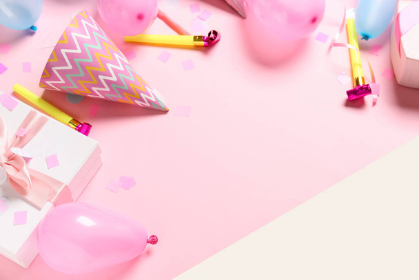 Конусы для вечеринок с воздушными шарами и подарочной коробкой на фоне цвета - Фото, изображение