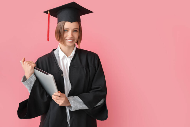 Female graduating student with laptop on color background - Photo, Image