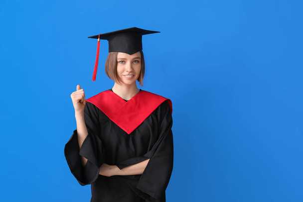 Happy female graduating student on color background - Фото, зображення