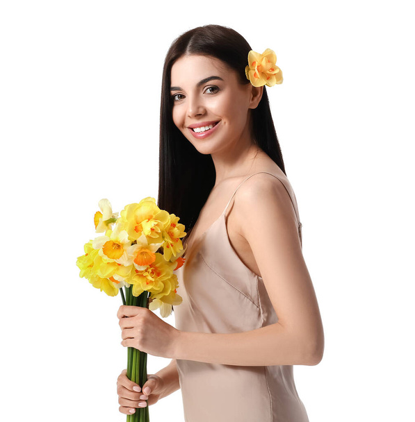 Beautiful young woman with narcissus bouquet on white background - Photo, Image