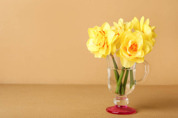 Vase with beautiful narcissus flowers on color background - Fotó, kép