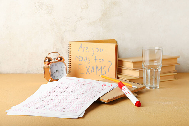 Antwortblätter, Schreibwaren, Wecker und Notizbuch mit Text SIND SIE bereit für Prüfungen? auf dem Tisch - Foto, Bild