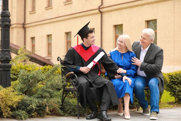 Joyeux jeune homme avec ses parents le jour de la remise des diplômes - Photo, image