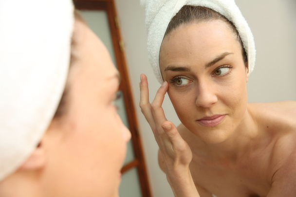 Woman looking in mirror - Foto, imagen