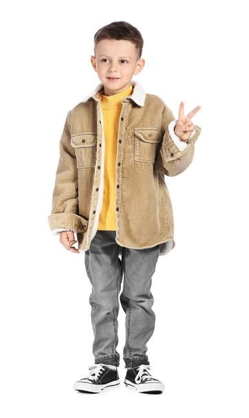 Portrait of cute little boy showing victory gesture on white background - Foto, imagen