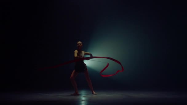 Flexibele sportvrouw die lint spint. Gymnast oefenen ritmische gymnastiek - Video