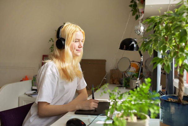 Chica adolescente sentado en casa dibujo en la computadora usando gráficos tableta - Foto, imagen