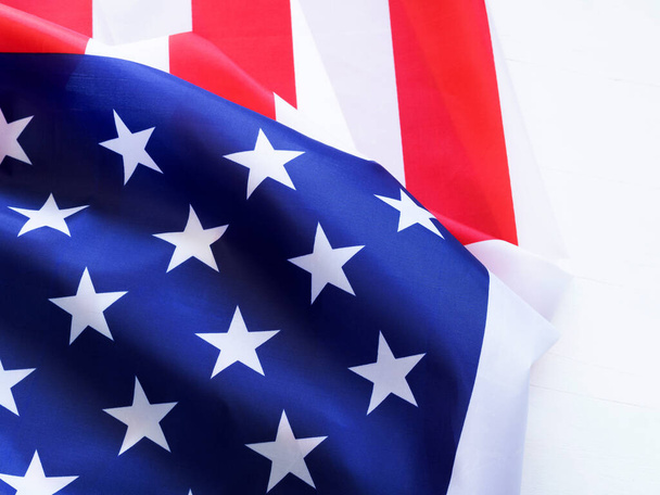 Detailní záběr, krásná tkanina americká vlajka na bílém dřevěném pozadí. Koncept dne nezávislosti. Kopírovat místo pro text. - Fotografie, Obrázek