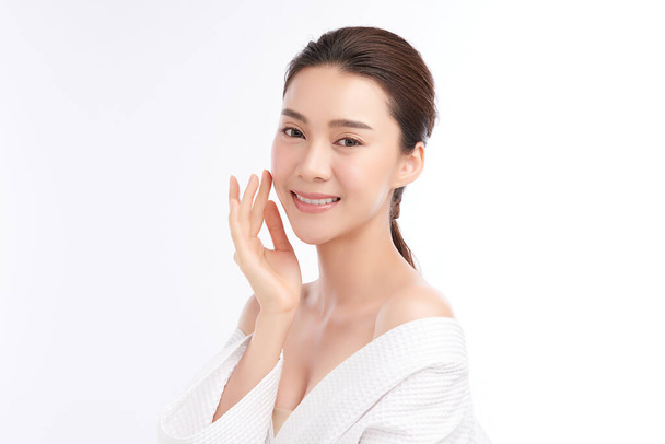 Hermosa mujer asiática joven con albornoz sobre fondo blanco, Cuidado de la cara, Tratamiento facial, Cosmetología, belleza y spa Concepto. - Foto, imagen