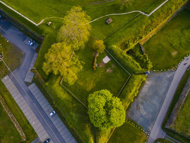 An overhead shot of a city park with green fields and a parking space - Фото, зображення