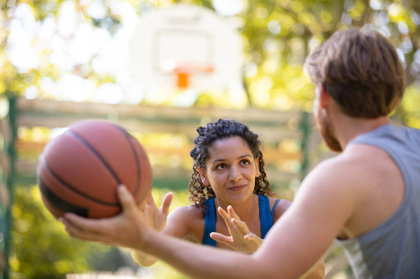 couple playing basketball on outdoor court - Фото, зображення