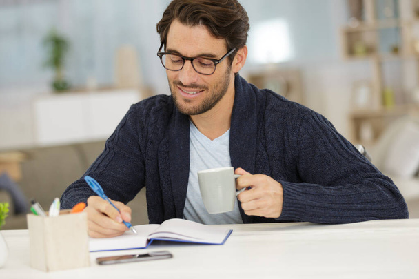 young businessman with coffee cup writting notes - Foto, imagen