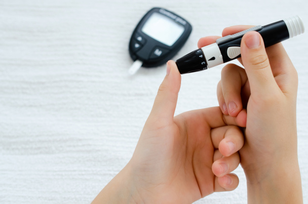 Diabetes and Glycemia. Blood sugar testing, child finger lancet punctures. - Photo, Image