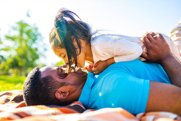 latin hispanic man with cute baby celebrating fathers day at picnic in sunny park - Photo, image